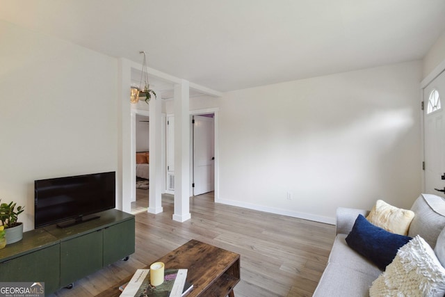 living area featuring light wood-style floors and baseboards