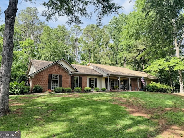 ranch-style house featuring a porch, brick siding, and a front yard