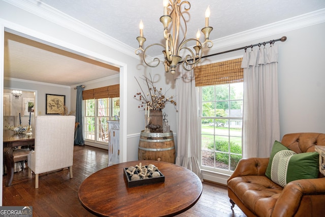 living area with crown molding, a wealth of natural light, hardwood / wood-style floors, and a chandelier