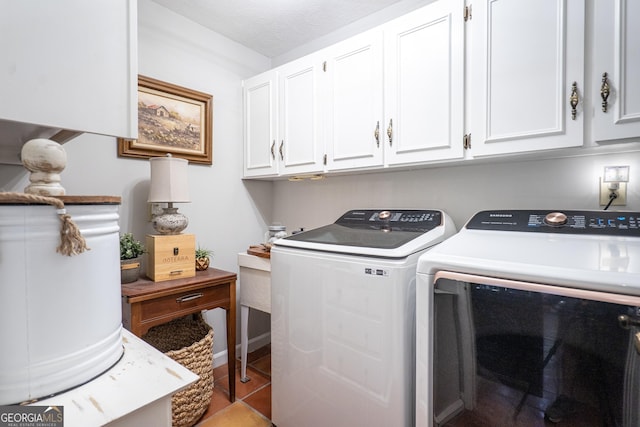 washroom featuring cabinet space, baseboards, and washer and clothes dryer