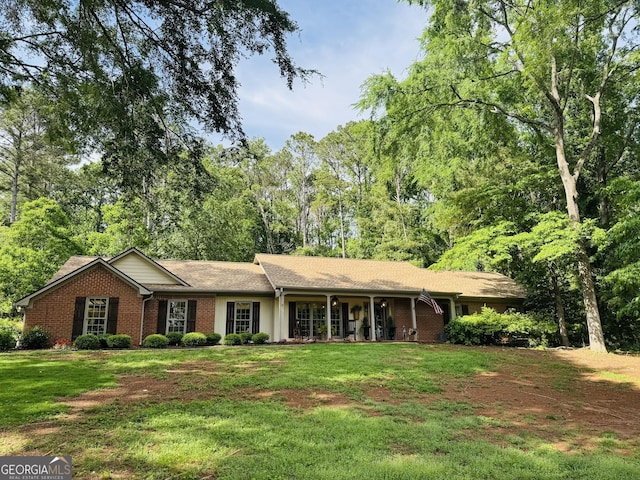 ranch-style house with a porch, brick siding, and a front yard