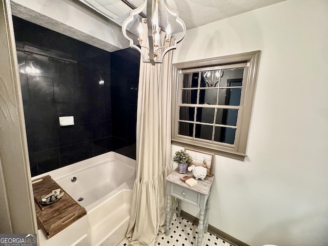 full bath with baseboards, a notable chandelier, and shower / bath combo