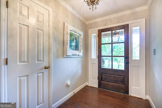 foyer entrance with dark wood-style flooring, baseboards, a notable chandelier, and ornamental molding
