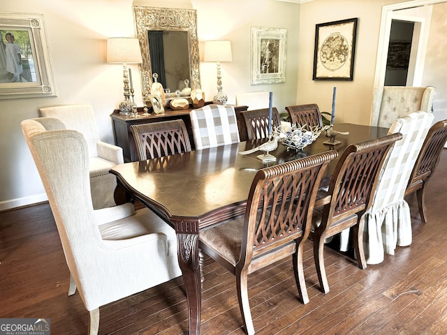 dining space with baseboards and wood finished floors