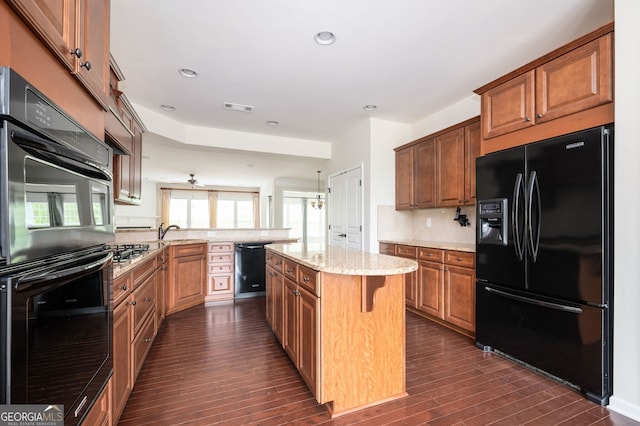 6732 Chimney Ridge Ct, Hoschton, GA 30548 - kitchen with black appliances, a peninsula, dark wood finished floors, light stone counters, and tasteful backsplash