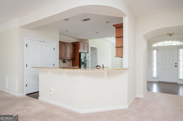 6732 Chimney Ridge Ct, Hoschton, GA 30548 - kitchen featuring fridge with ice dispenser, arched walkways, carpet floors, a kitchen bar, and light stone counters