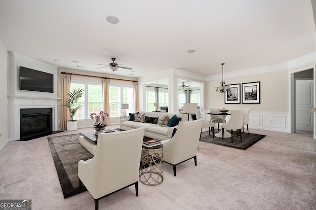 6732 Chimney Ridge Ct, Hoschton, GA 30548 - living room with light carpet, a ceiling fan, a fireplace with flush hearth, a wainscoted wall, and a chandelier