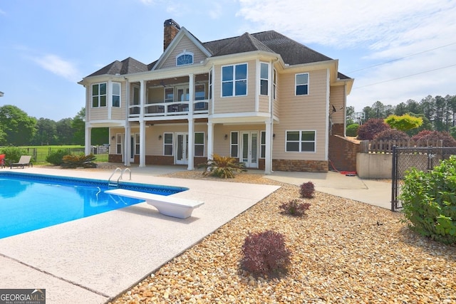 back of house with a patio, a fenced in pool, french doors, and a balcony