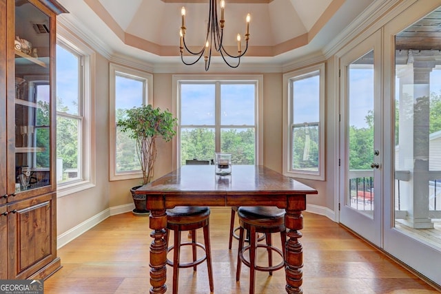 dining area with baseboards, plenty of natural light, light wood-type flooring, and a notable chandelier