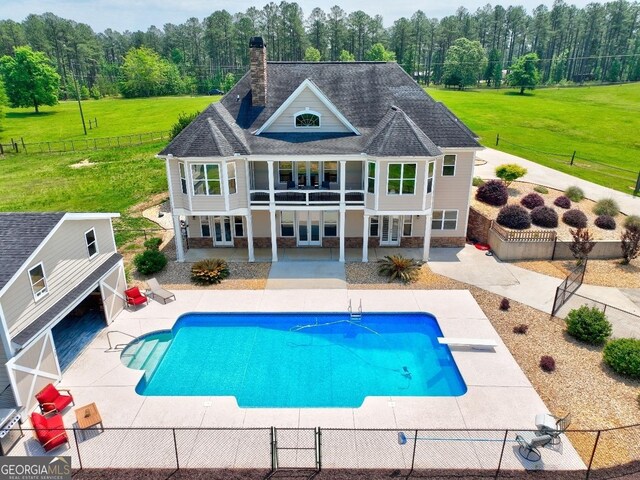 view of swimming pool with french doors, a lawn, a fenced in pool, a fenced backyard, and a patio