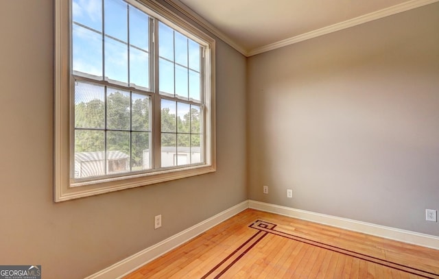 unfurnished room with baseboards, plenty of natural light, ornamental molding, and hardwood / wood-style flooring