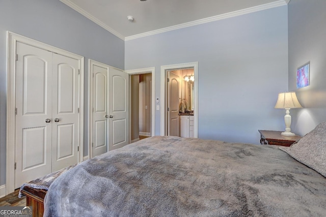bedroom featuring crown molding, connected bathroom, baseboards, and two closets