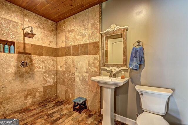 full bathroom featuring a tile shower, toilet, and wooden ceiling