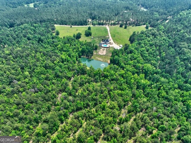 birds eye view of property with a water view and a wooded view