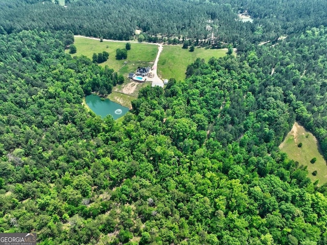 birds eye view of property featuring a water view and a wooded view