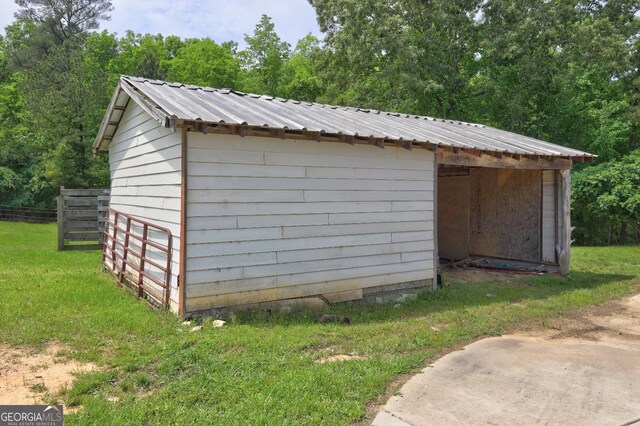view of outbuilding with fence and an outbuilding