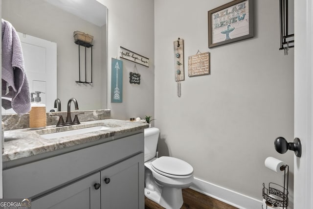 485 Lloyd St, Monticello, GA 31064 - half bathroom with vanity, wood finished floors, toilet, and baseboards