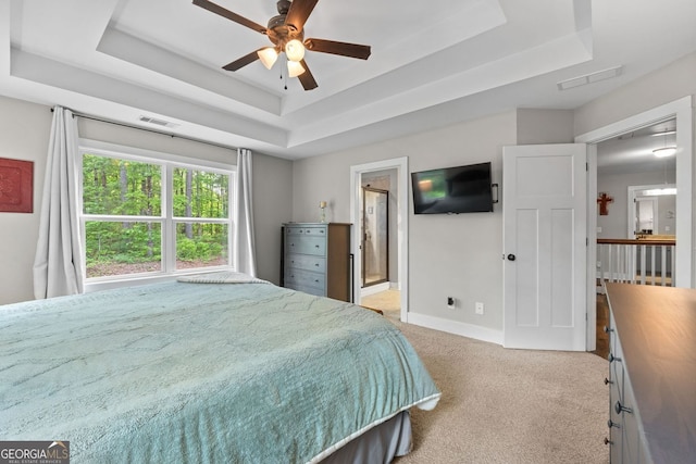 485 Lloyd St, Monticello, GA 31064 - bedroom with a tray ceiling, light colored carpet, baseboards, and connected bathroom