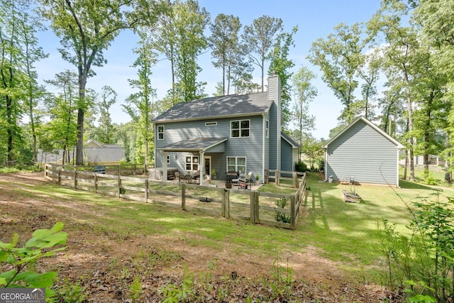 485 Lloyd St, Monticello, GA 31064 - rear view of house featuring a chimney, a patio area, and a vegetable garden