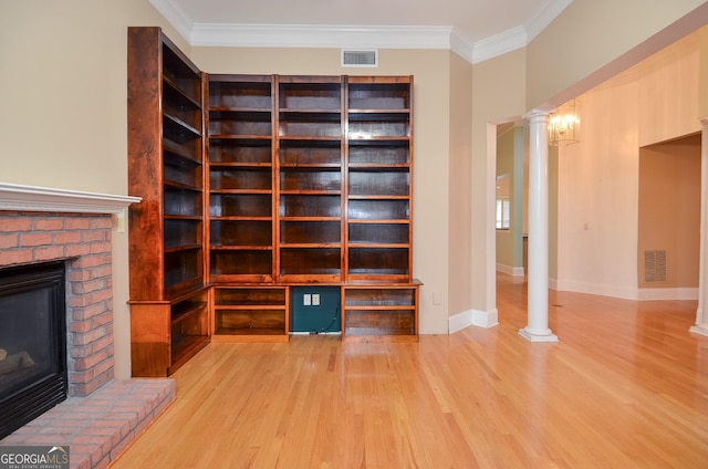 unfurnished living room featuring decorative columns, visible vents, wood finished floors, and a fireplace