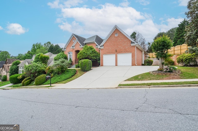 traditional-style house with brick siding, an attached garage, fence, and driveway
