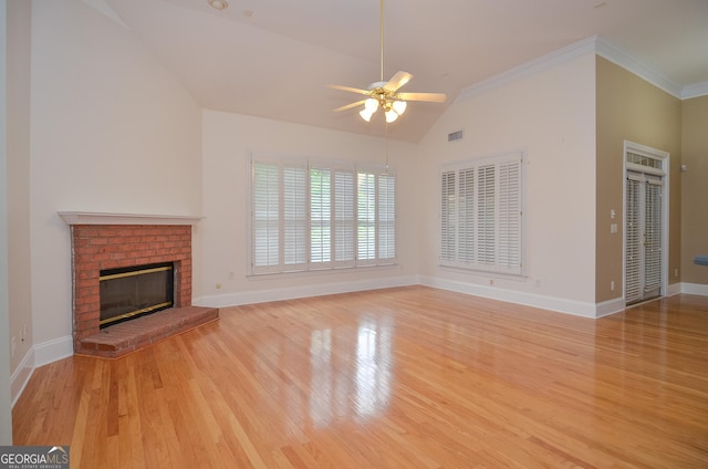 unfurnished living room with a brick fireplace, wood finished floors, baseboards, a ceiling fan, and vaulted ceiling