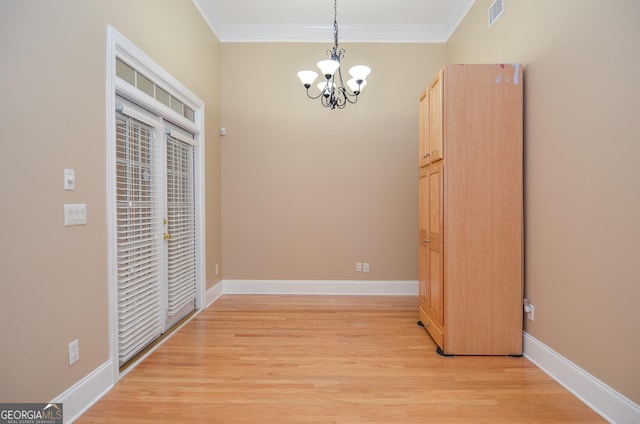 unfurnished dining area with crown molding, a notable chandelier, light wood-style flooring, and visible vents