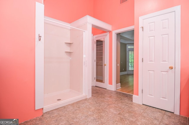 full bathroom with tile patterned floors, baseboards, and a stall shower