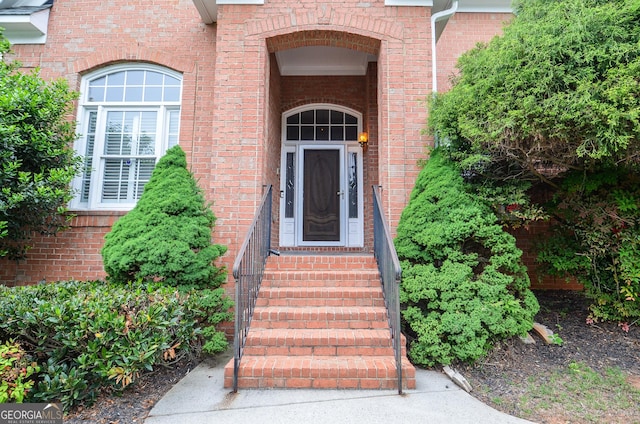view of exterior entry featuring brick siding