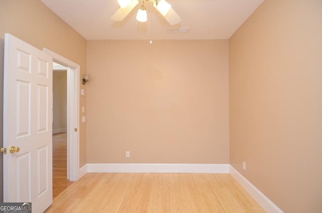 empty room featuring light wood-style floors, baseboards, a ceiling fan, and visible vents