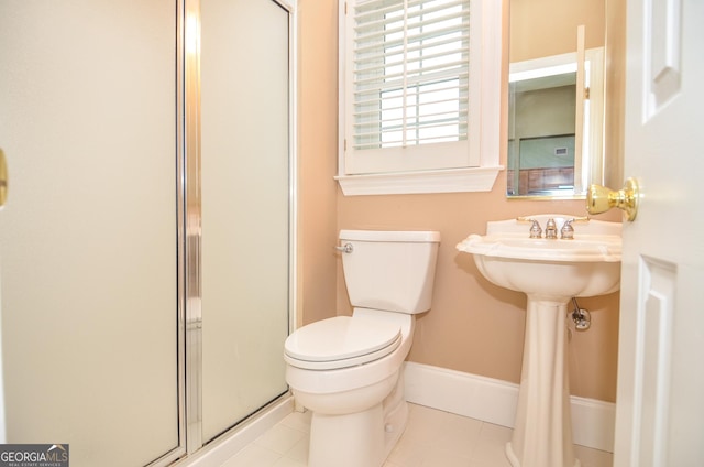 bathroom with baseboards, tile patterned flooring, a shower with door, and toilet