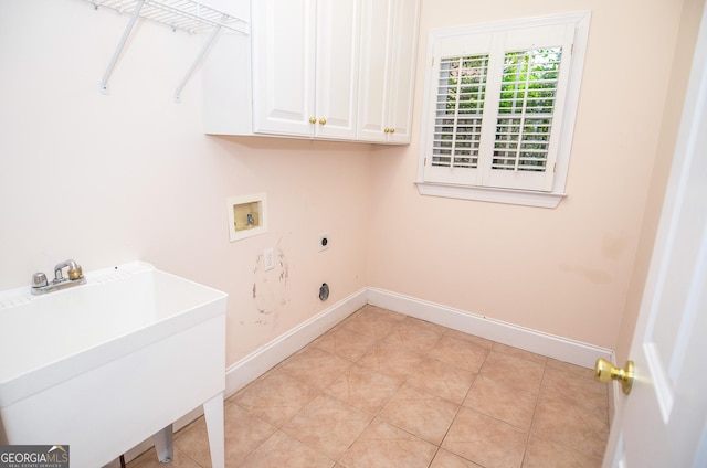 clothes washing area with baseboards, hookup for a washing machine, a sink, cabinet space, and hookup for an electric dryer