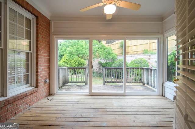 unfurnished sunroom with a ceiling fan