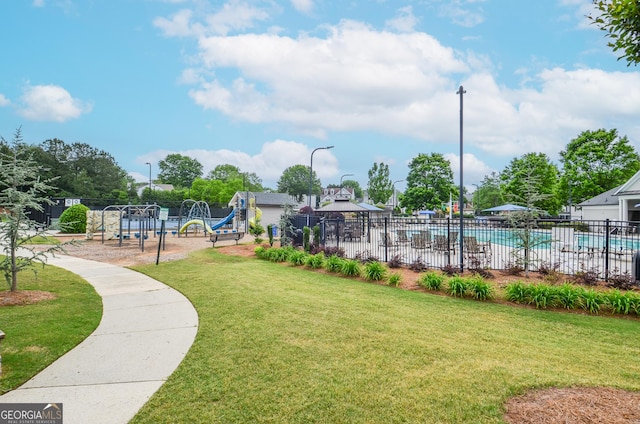 surrounding community featuring a lawn, a swimming pool, fence, and playground community