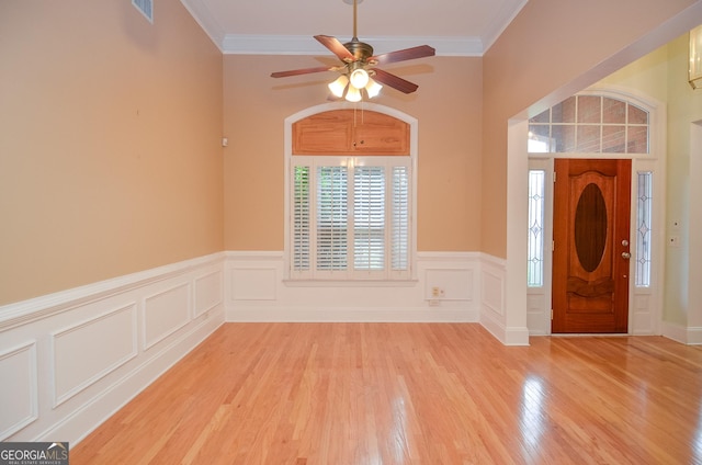 entrance foyer featuring crown molding, a ceiling fan, visible vents, and light wood-style floors