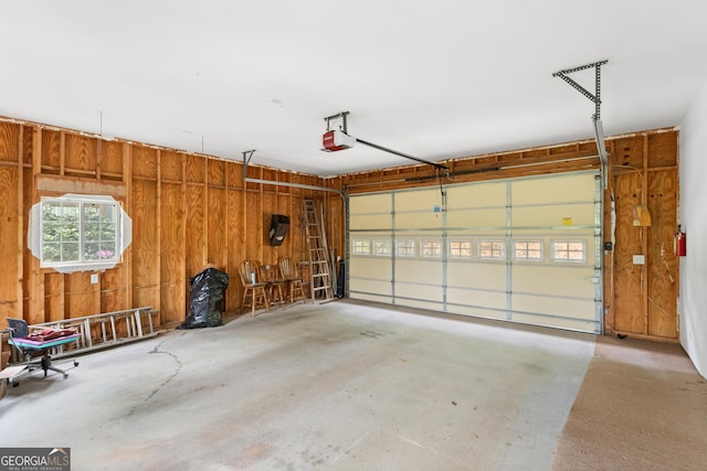 garage with wooden walls and a garage door opener