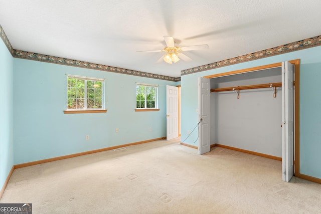 unfurnished bedroom with visible vents, baseboards, a closet, and light carpet