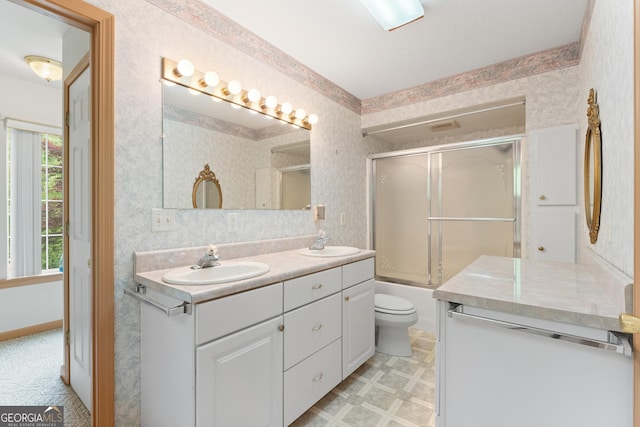 full bathroom featuring double vanity, a sink, toilet, and wallpapered walls