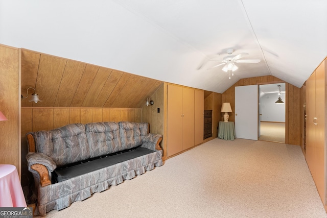 bonus room featuring wooden walls, ceiling fan, carpet flooring, and lofted ceiling
