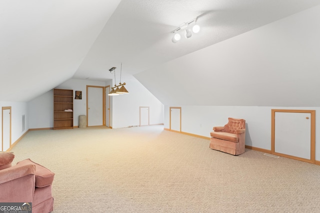 additional living space featuring baseboards, visible vents, carpet, and lofted ceiling