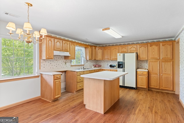 kitchen featuring visible vents, white appliances, light countertops, under cabinet range hood, and light wood finished floors