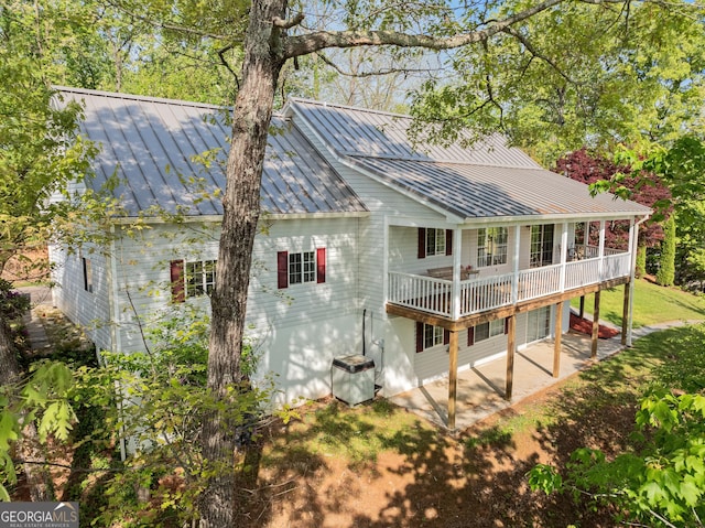back of property featuring a standing seam roof, a patio area, and metal roof