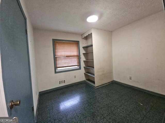 1517 Colony E Cir, Stone Mountain, GA 30083 - empty room featuring dark floors, baseboards, a textured ceiling, and visible vents