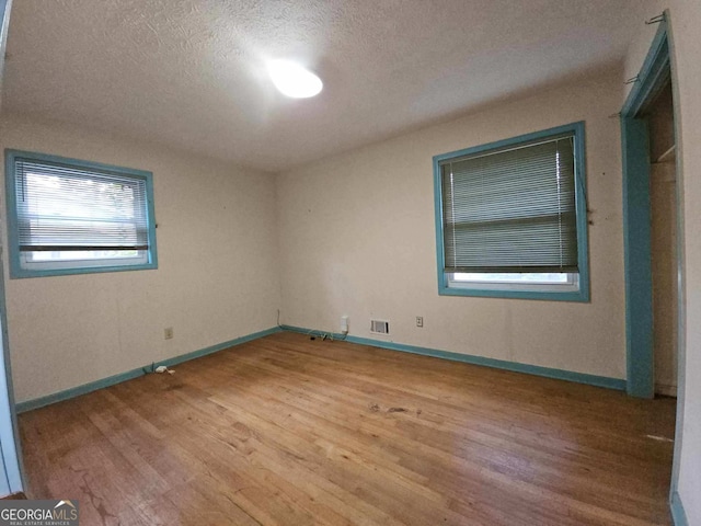 1517 Colony E Cir, Stone Mountain, GA 30083 - unfurnished room featuring a textured ceiling, baseboards, wood finished floors, and visible vents