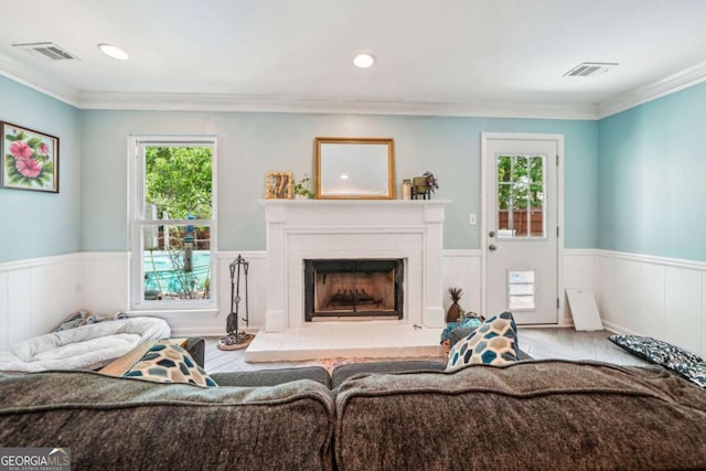 living area with a healthy amount of sunlight, wainscoting, and visible vents