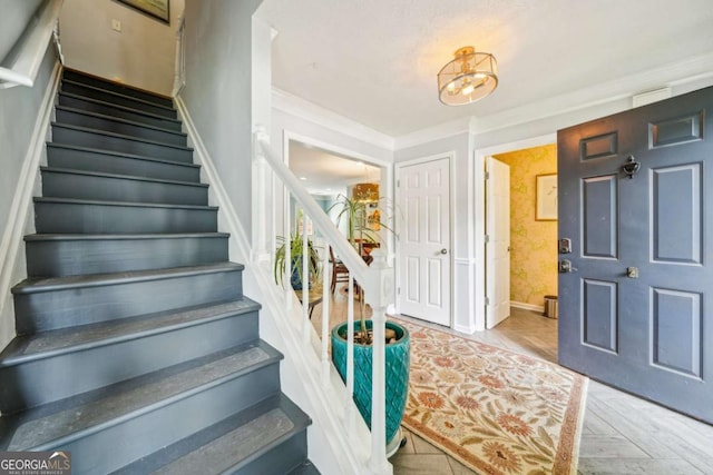 stairs featuring baseboards and crown molding