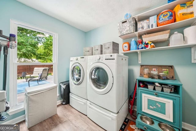 washroom with laundry area, a textured ceiling, wood finished floors, baseboards, and separate washer and dryer
