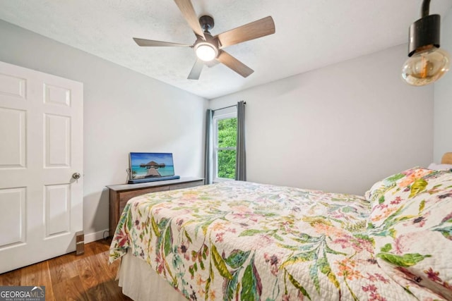 bedroom featuring baseboards, a ceiling fan, and wood finished floors