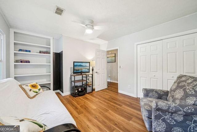 living room featuring baseboards, ceiling fan, visible vents, and wood finished floors