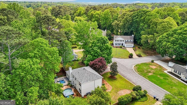 birds eye view of property featuring a view of trees